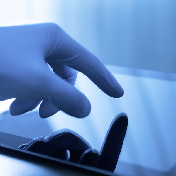 hand wearing a latex glove operates a touchscreen hand wearing a latex glove operates a touchscreen